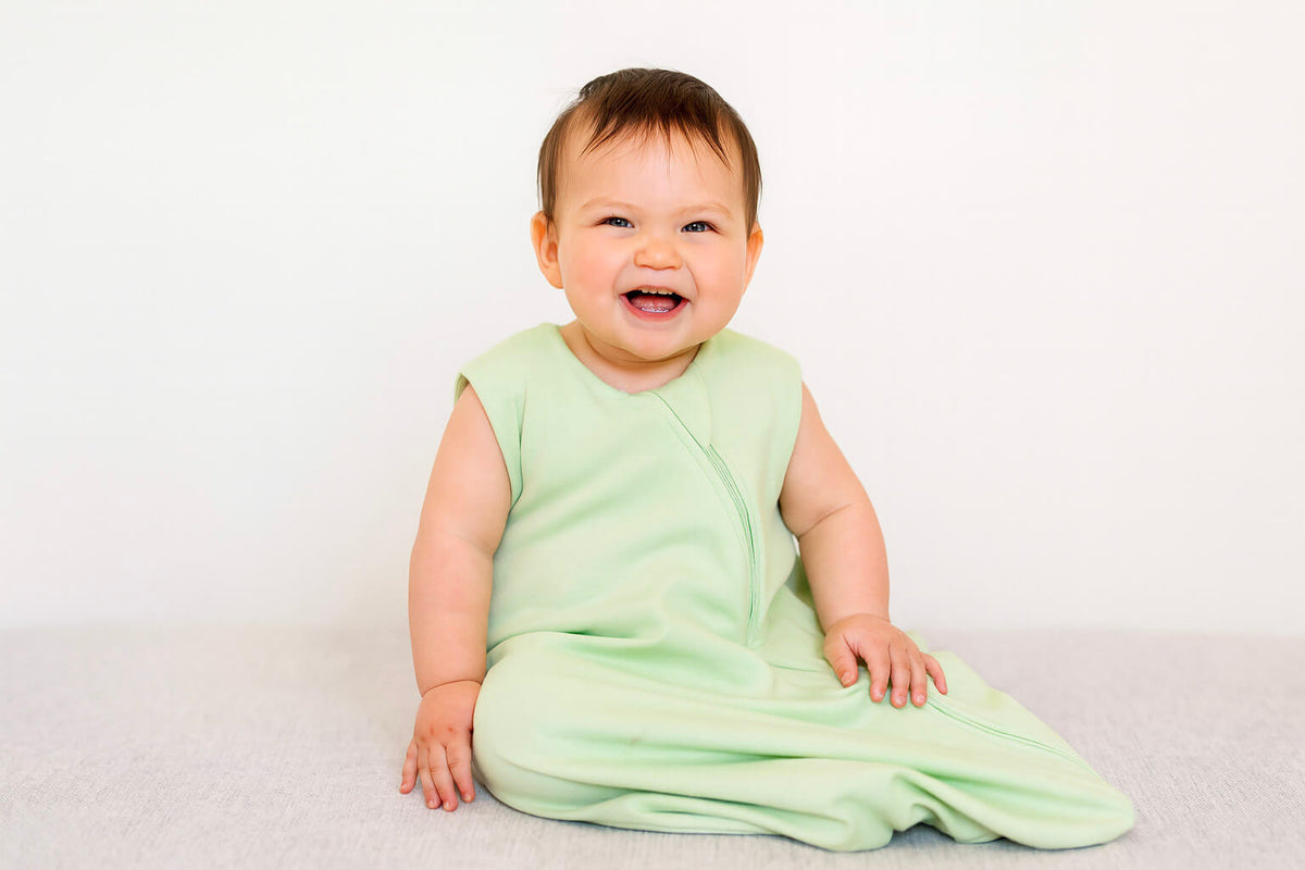 baby wearing green sleep sack