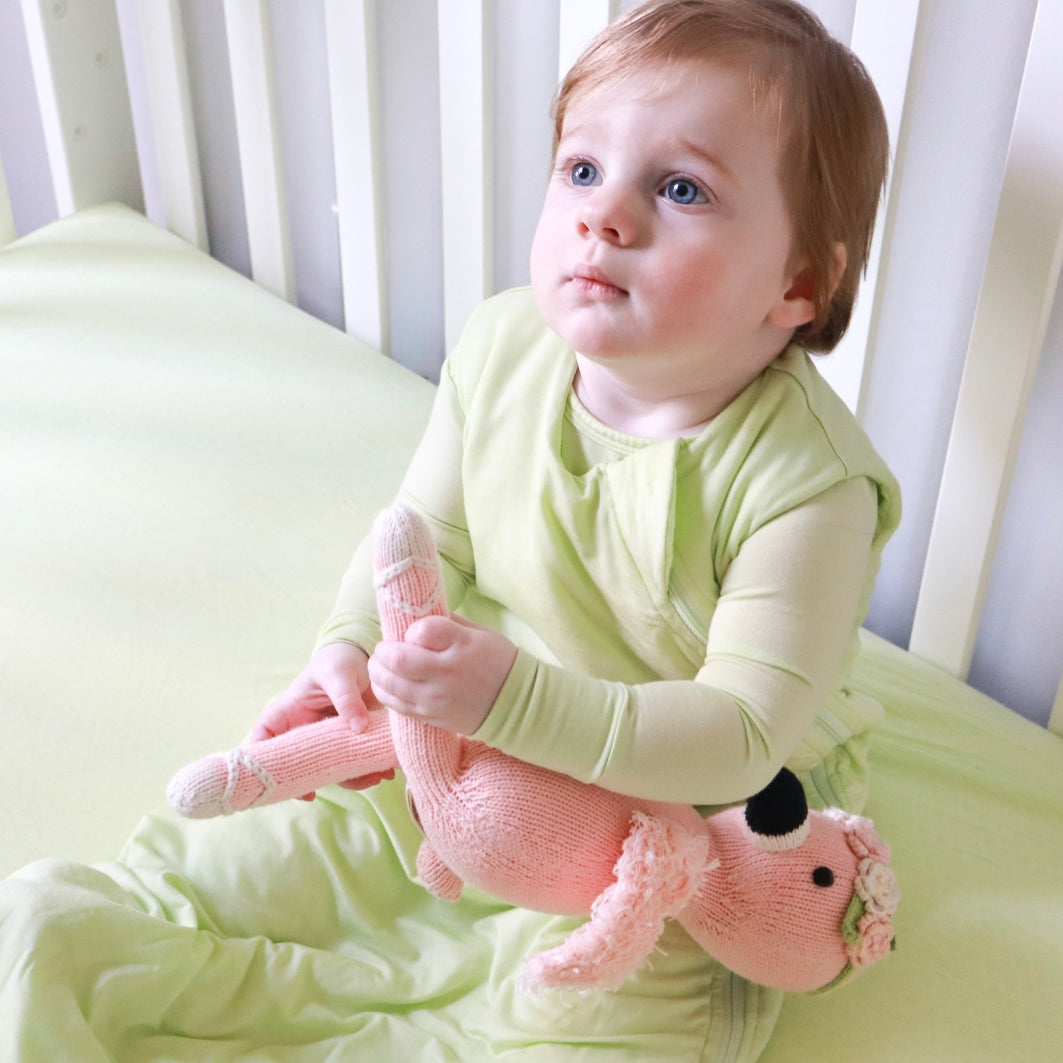 little girl wearing green sleep sack
