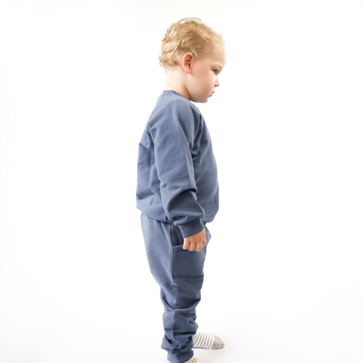 toddler standing up wearing blue jogger