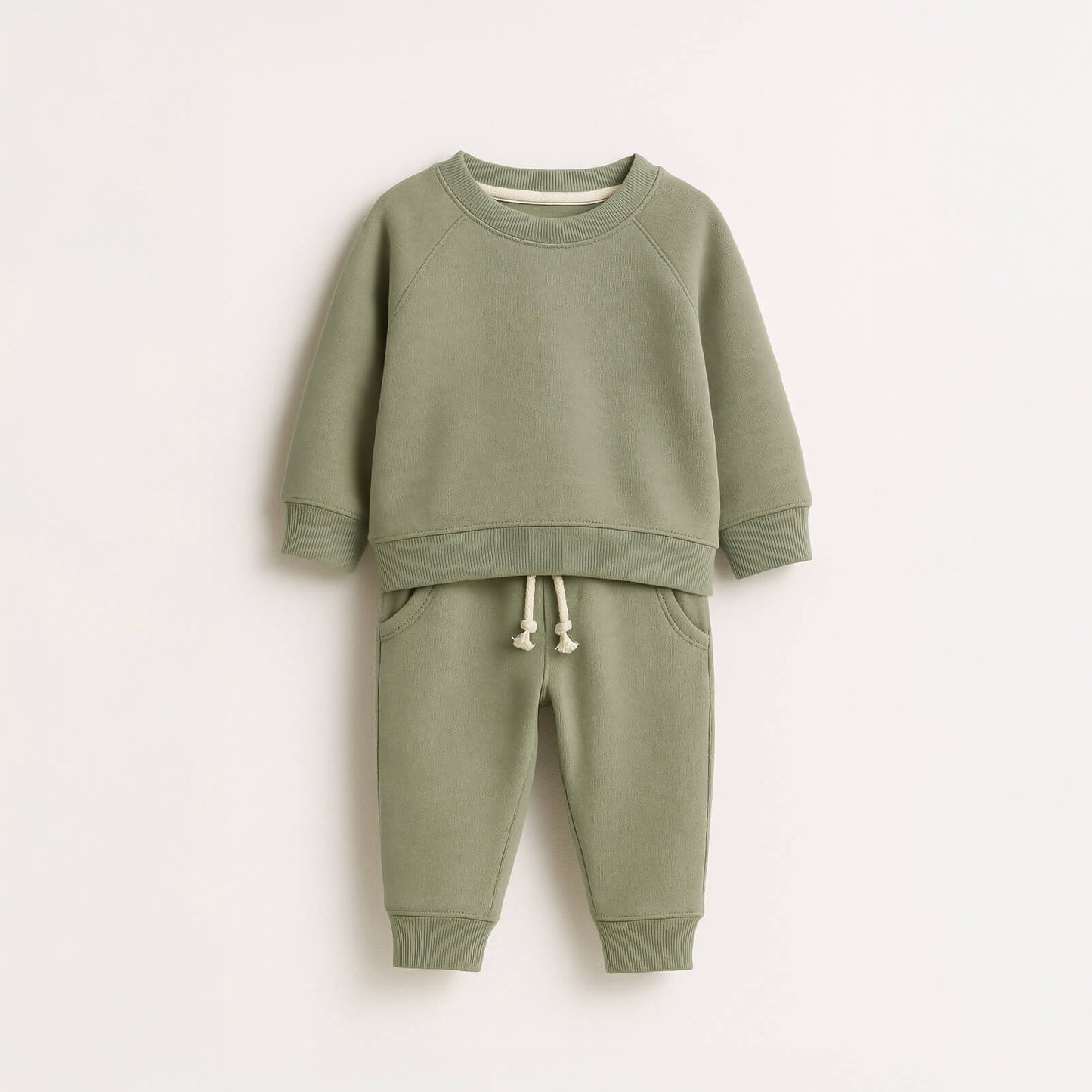 Green children's sweatshirt and pants set on a white background