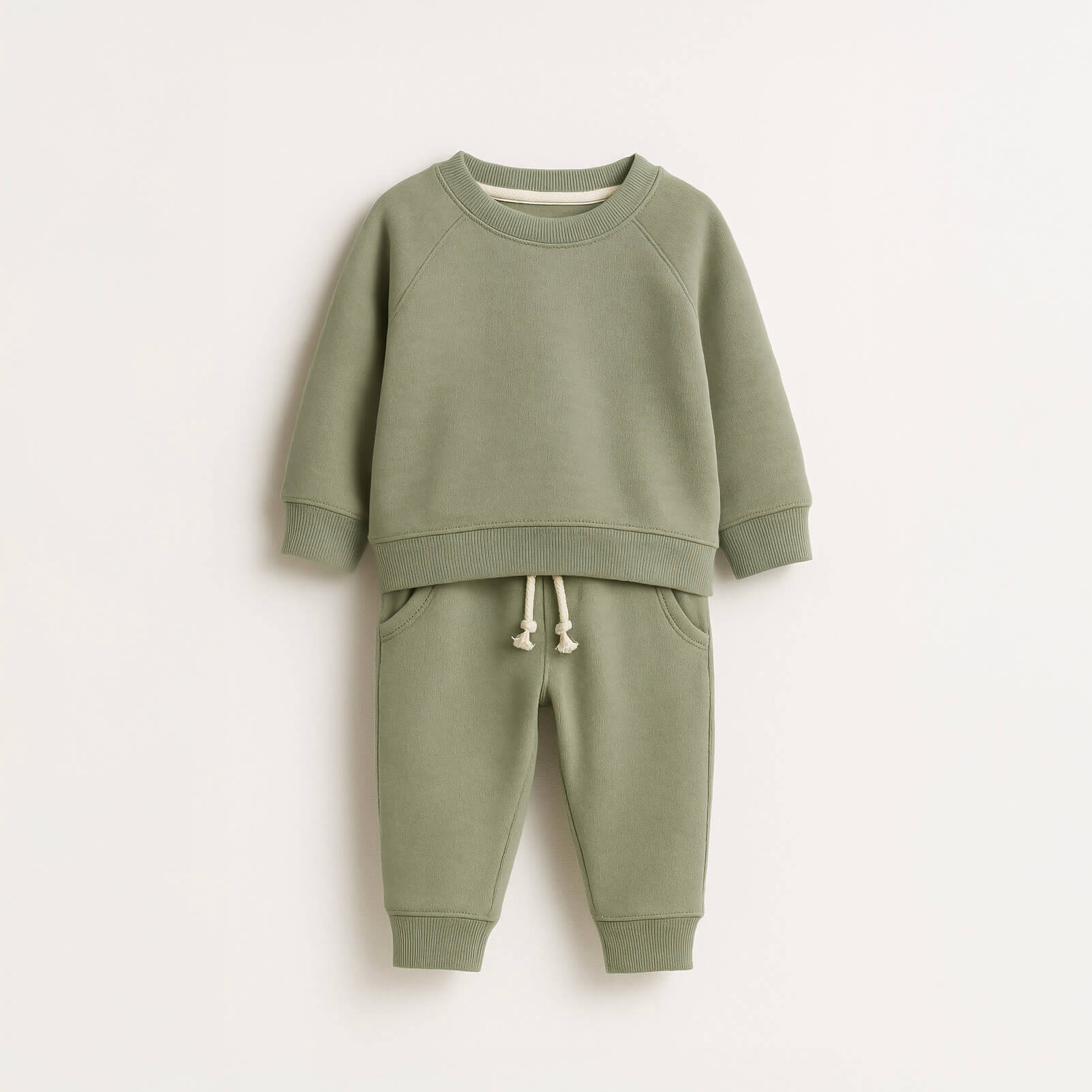 Green children's sweatshirt and pants set on a white background