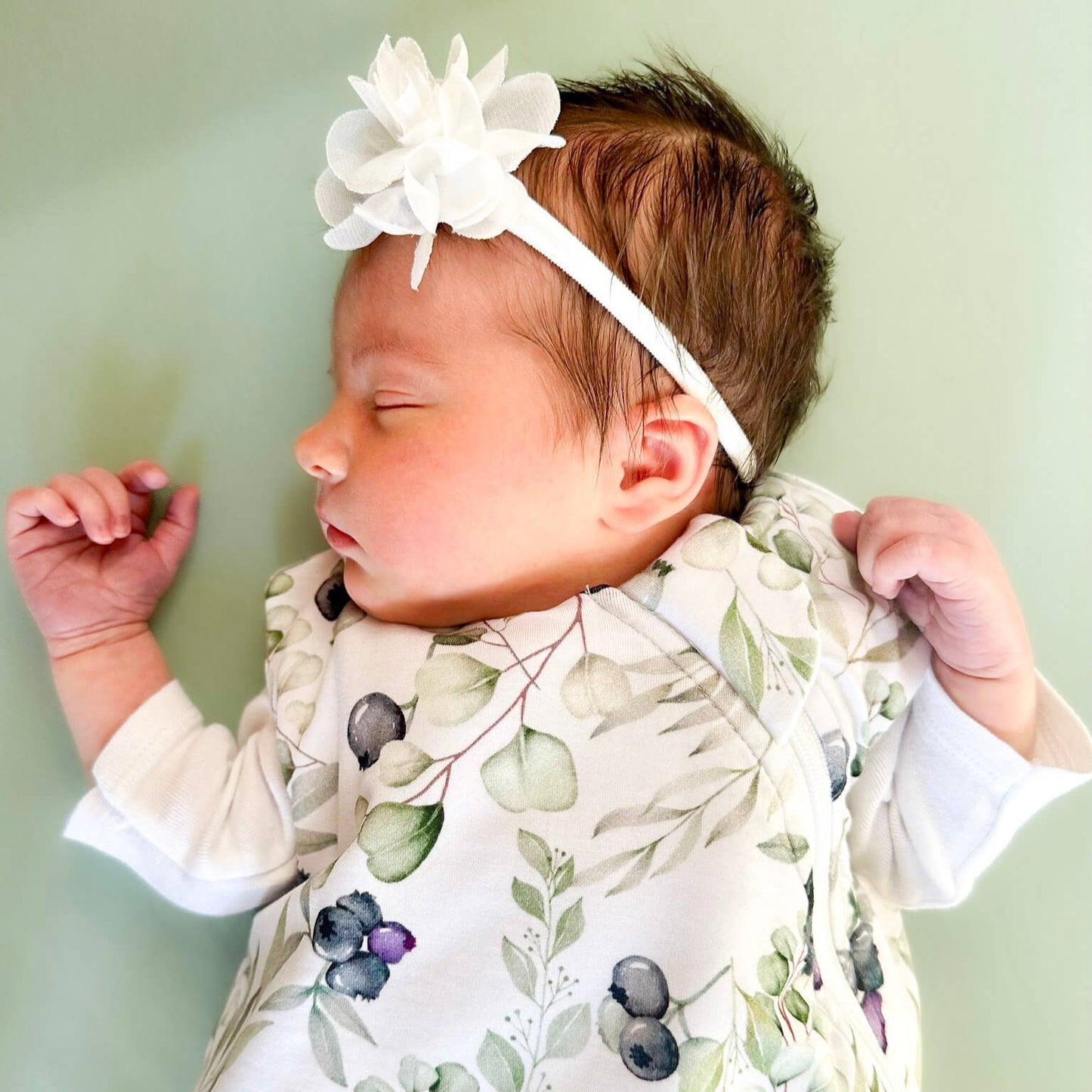 Baby wearing sleep sack in blueberries