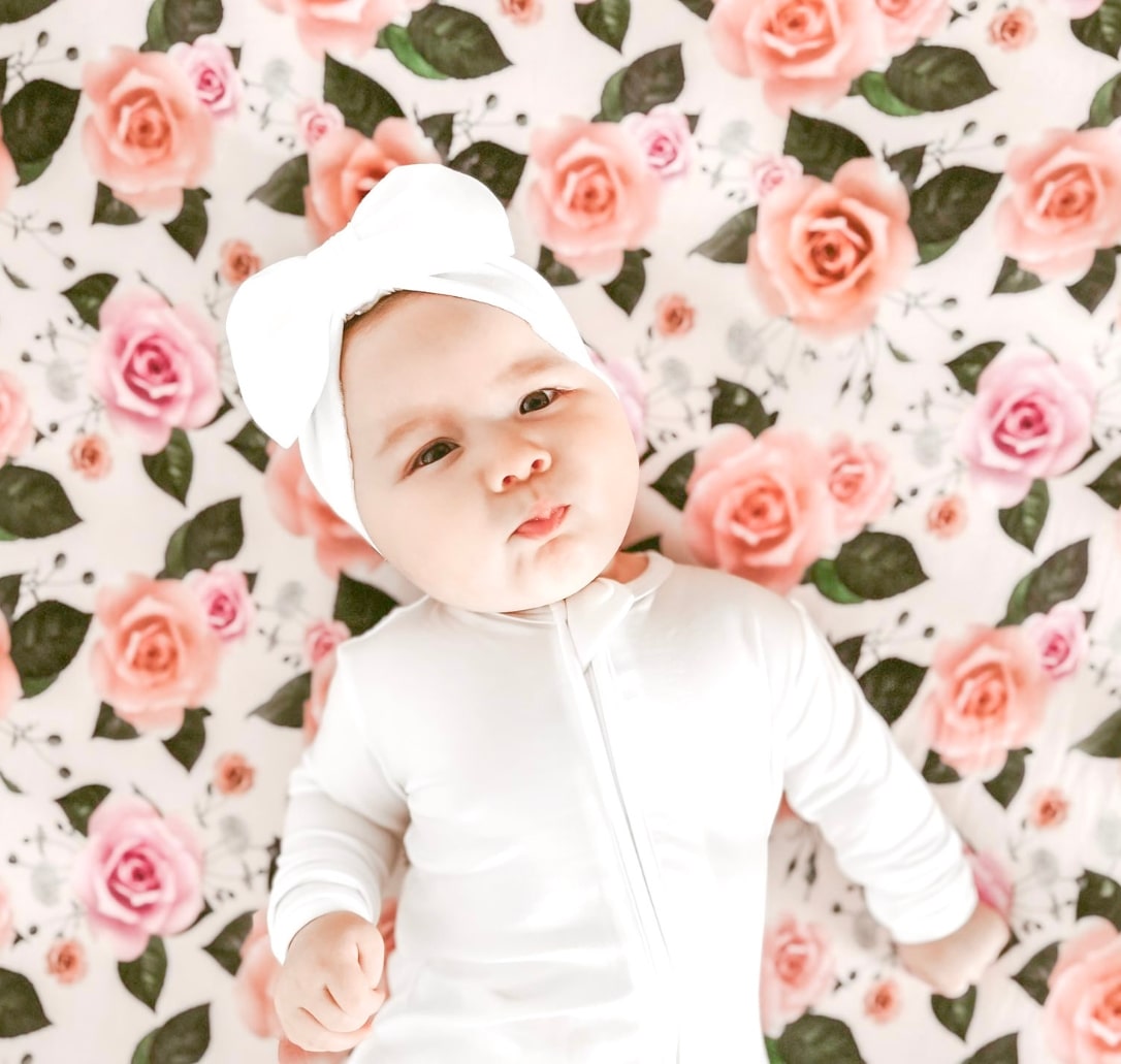 Baby girl wearing white sleepers