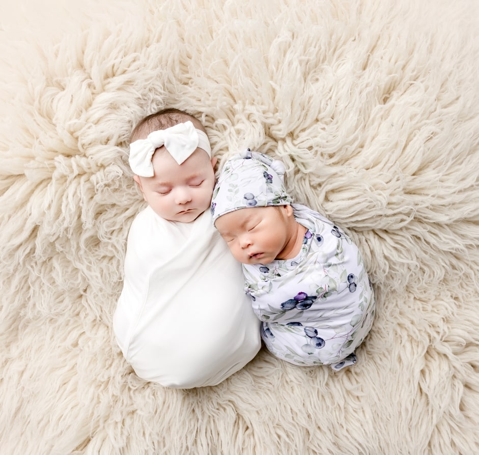 Newborn babies sleeping using cuddle sprouts swaddles