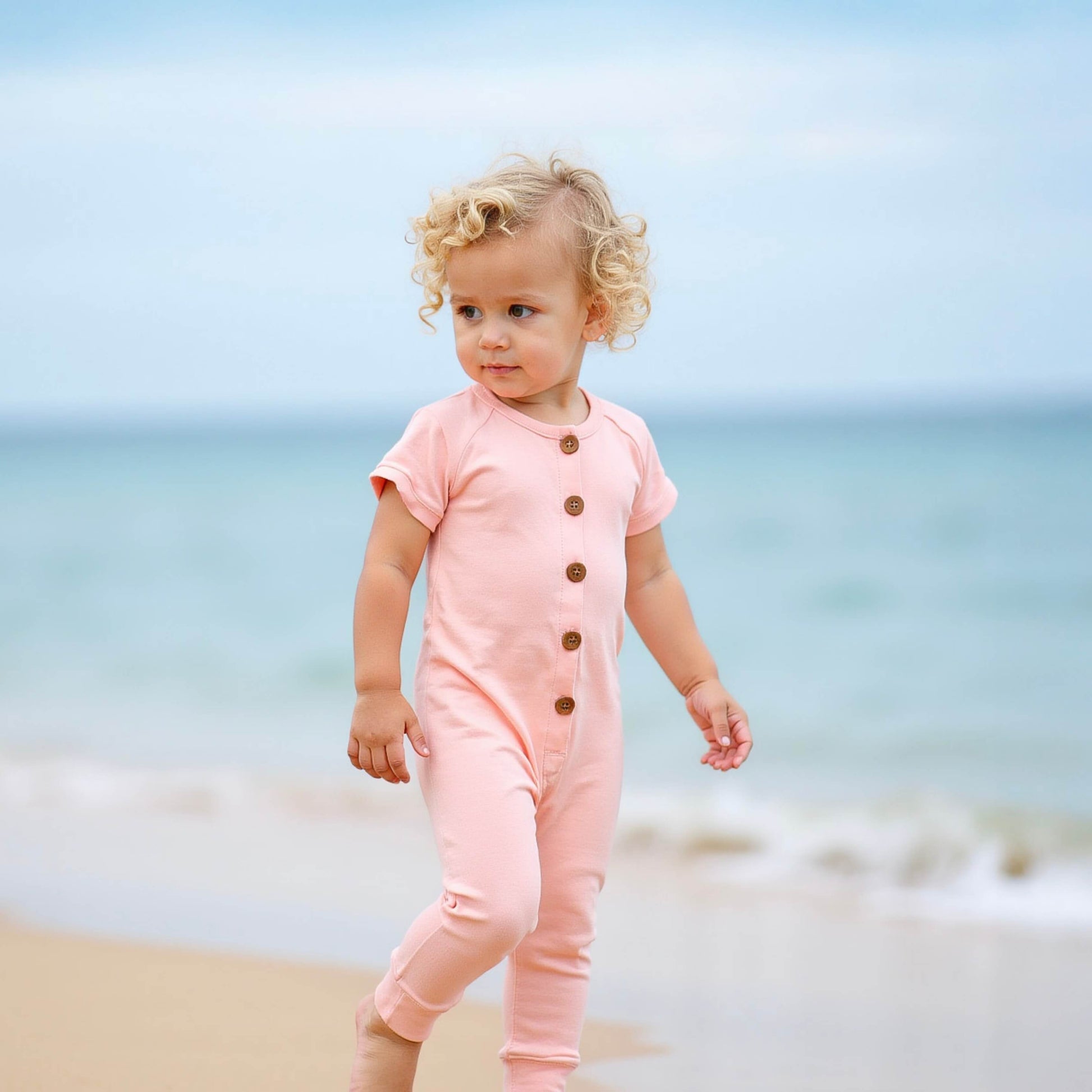 blond toddler wearing pink romper