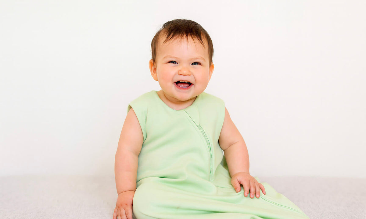 baby wearing green sleep sack