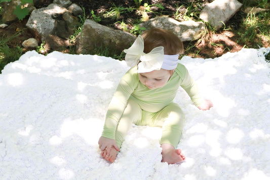 baby girl outdoors wearing green pajama