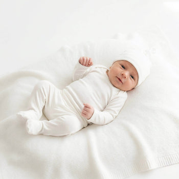 newborn baby wearing white outfit 