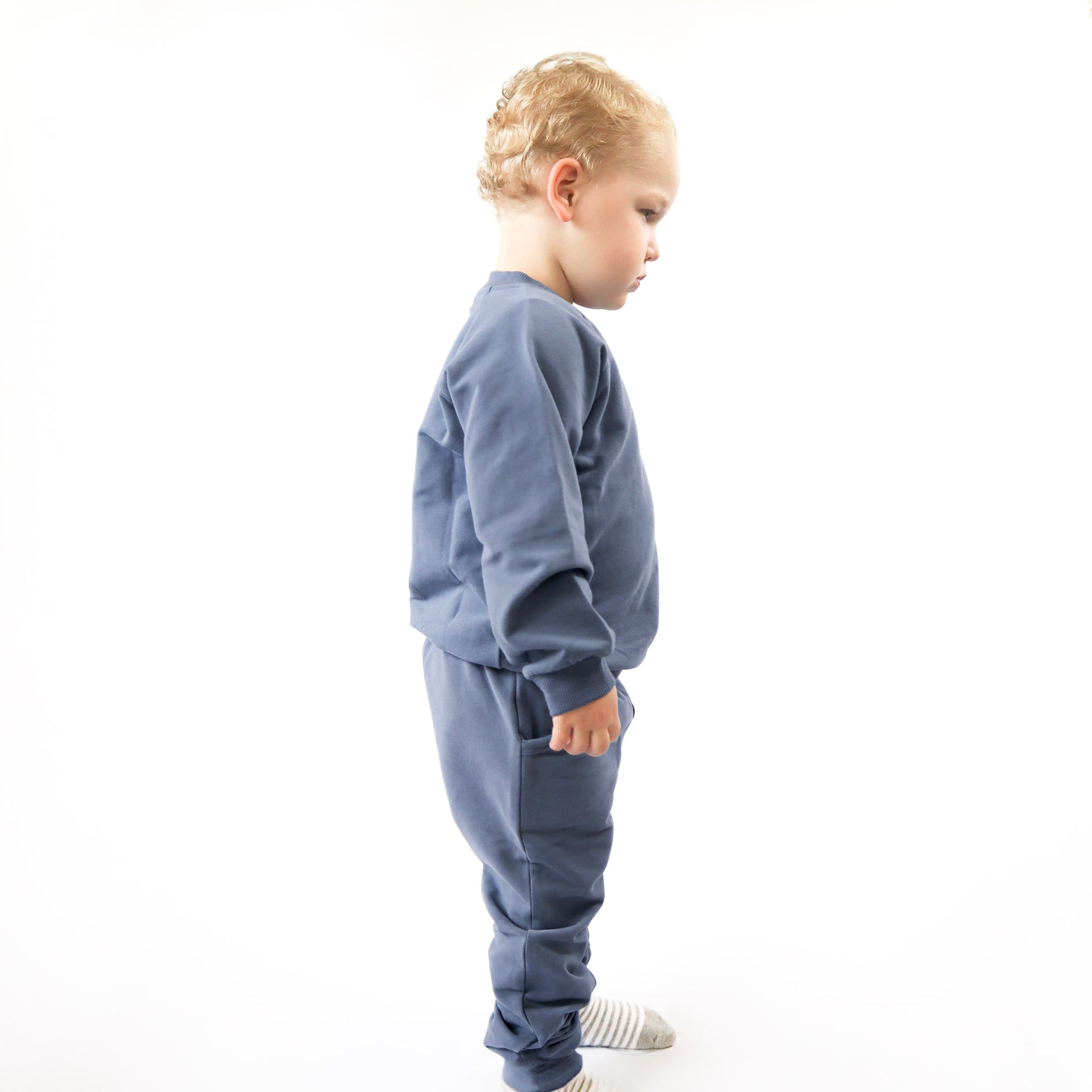 toddler standing up wearing blue jogger 