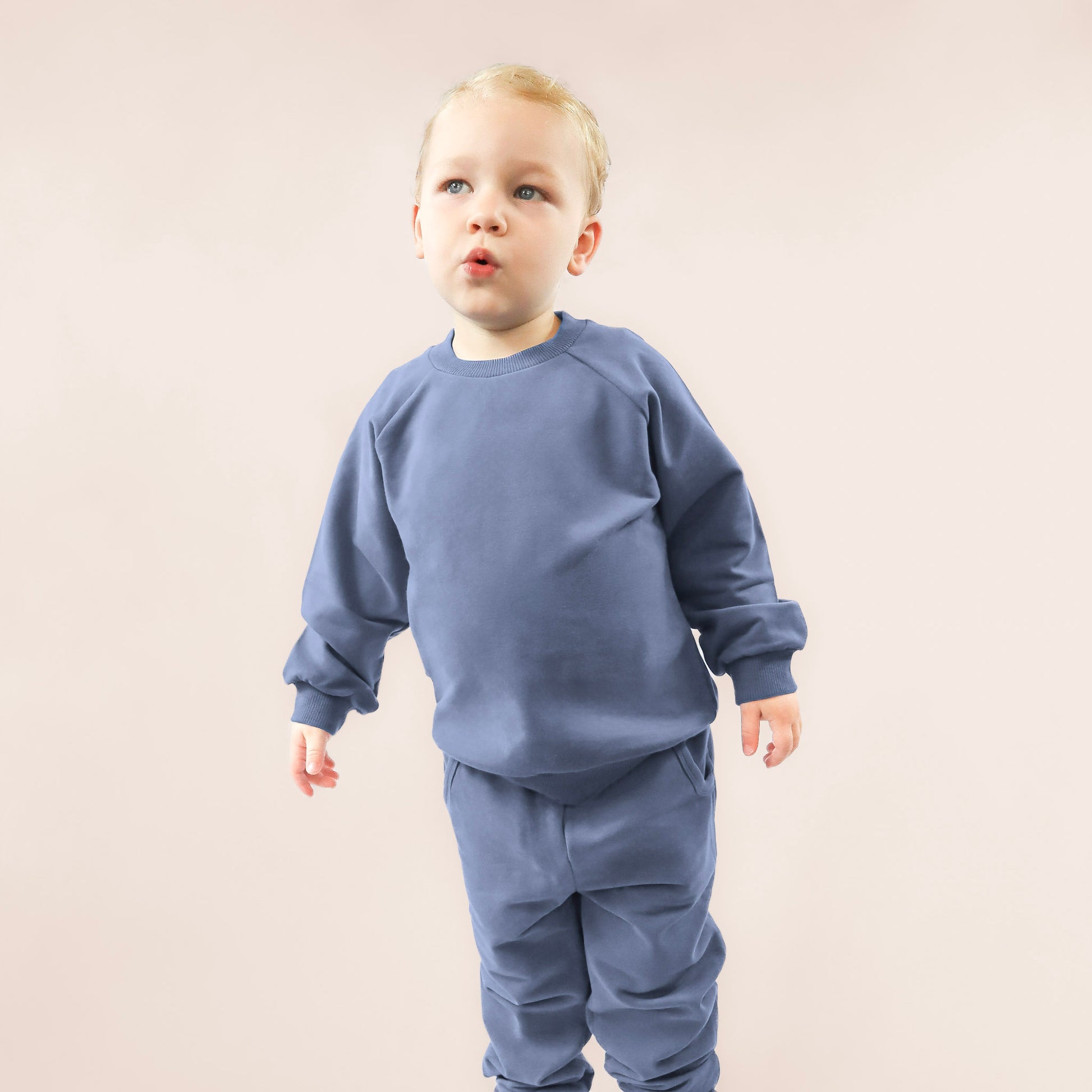 toddler standing up wearing blue organic cotton jogger set