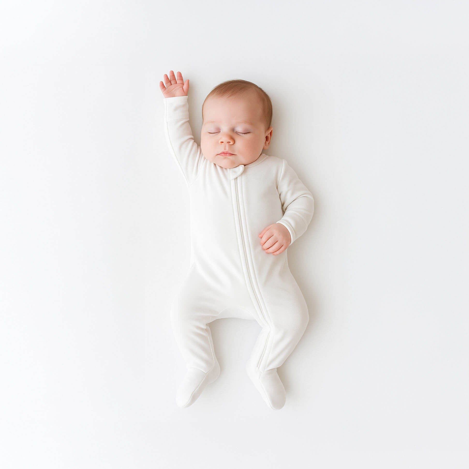 Newborn wearing white footie 