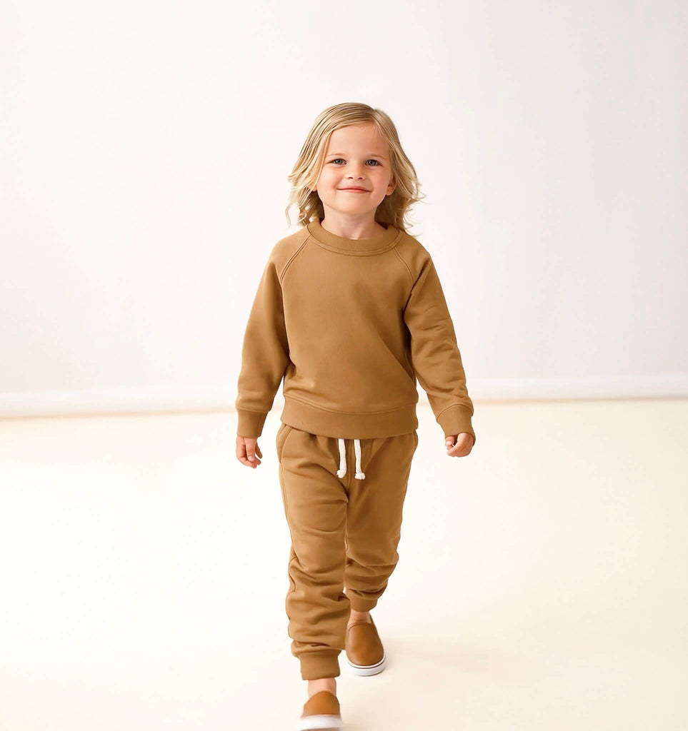 Child wearing a brown outfit on a white background