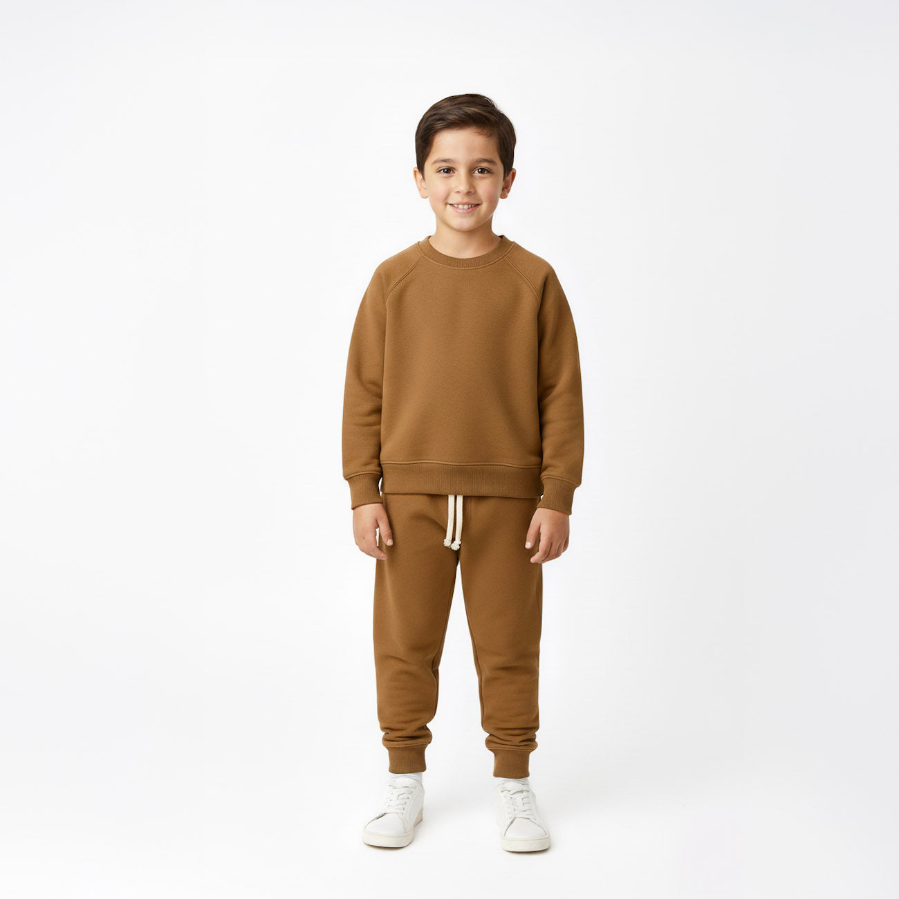 Child wearing a brown sweatshirt and pants set on a white background