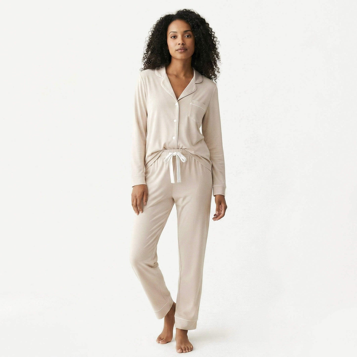 Woman wearing a beige pajama set on a white background