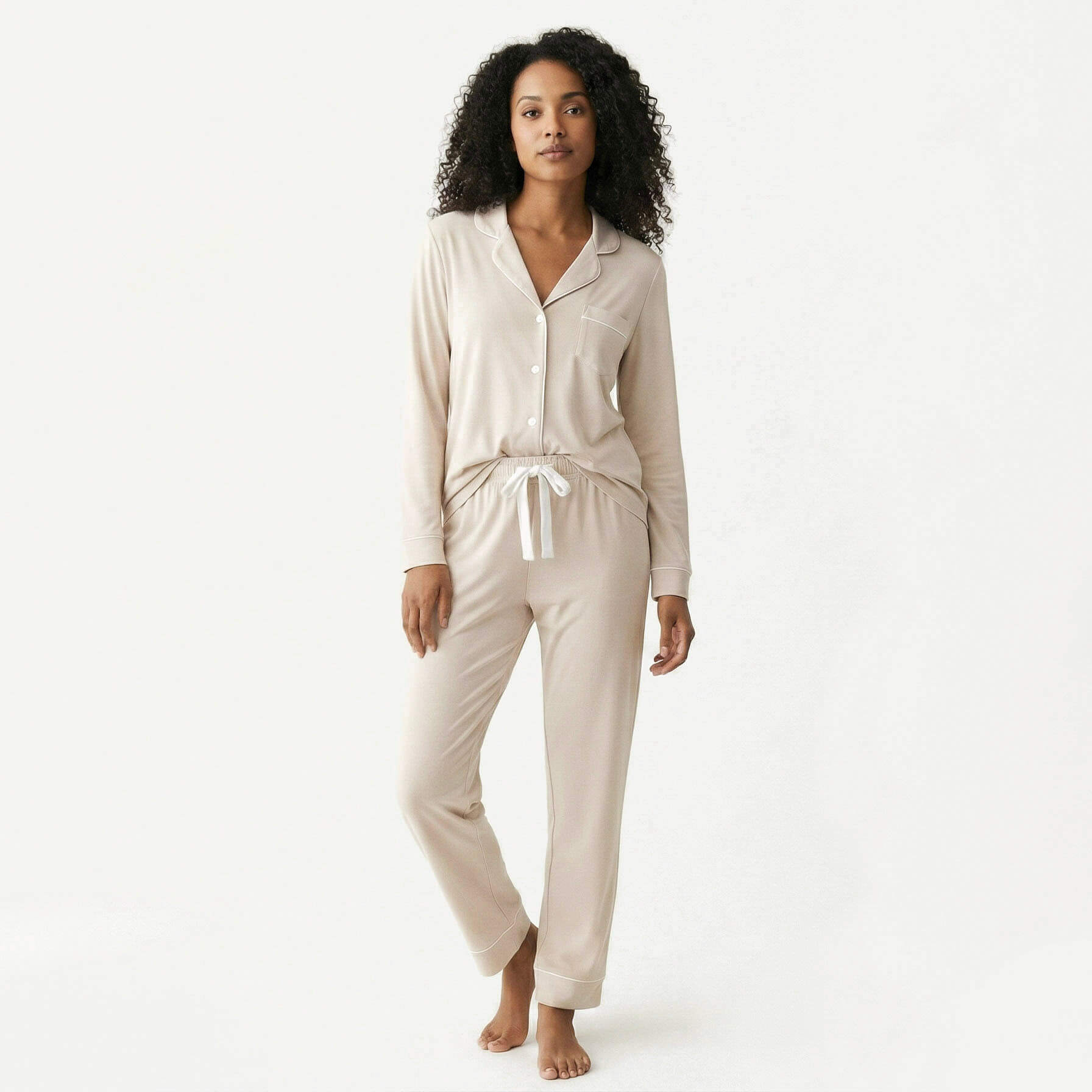 Woman wearing a beige pajama set on a white background