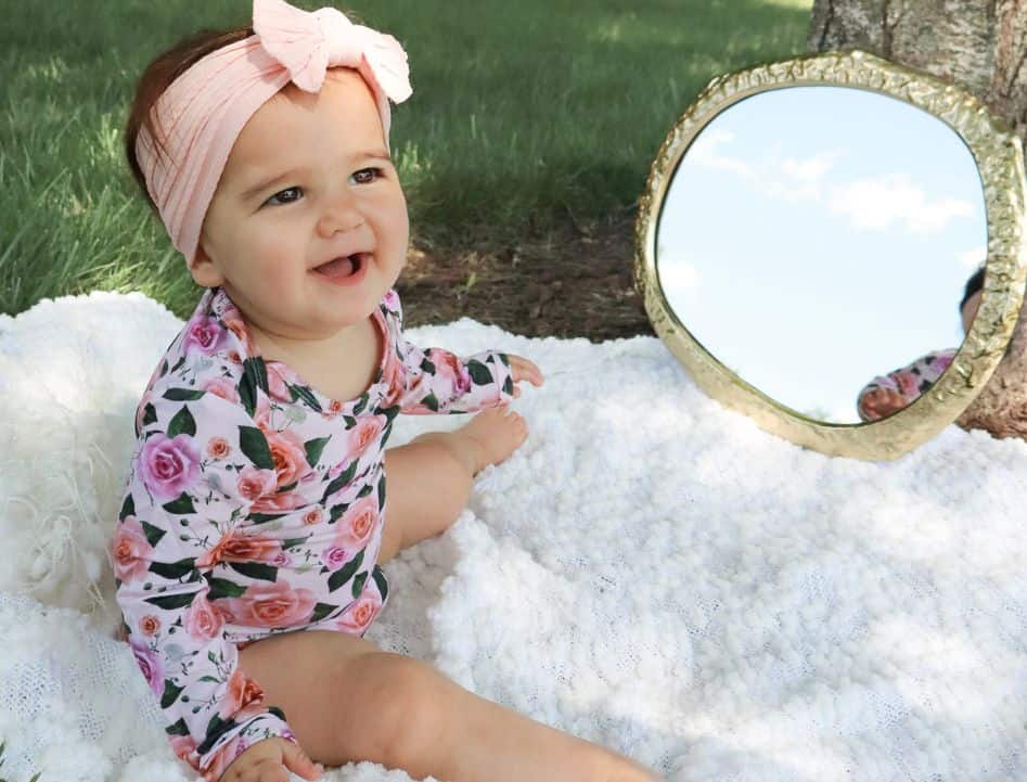 Baby girl wearing tencel roses bodysuit while outdoors