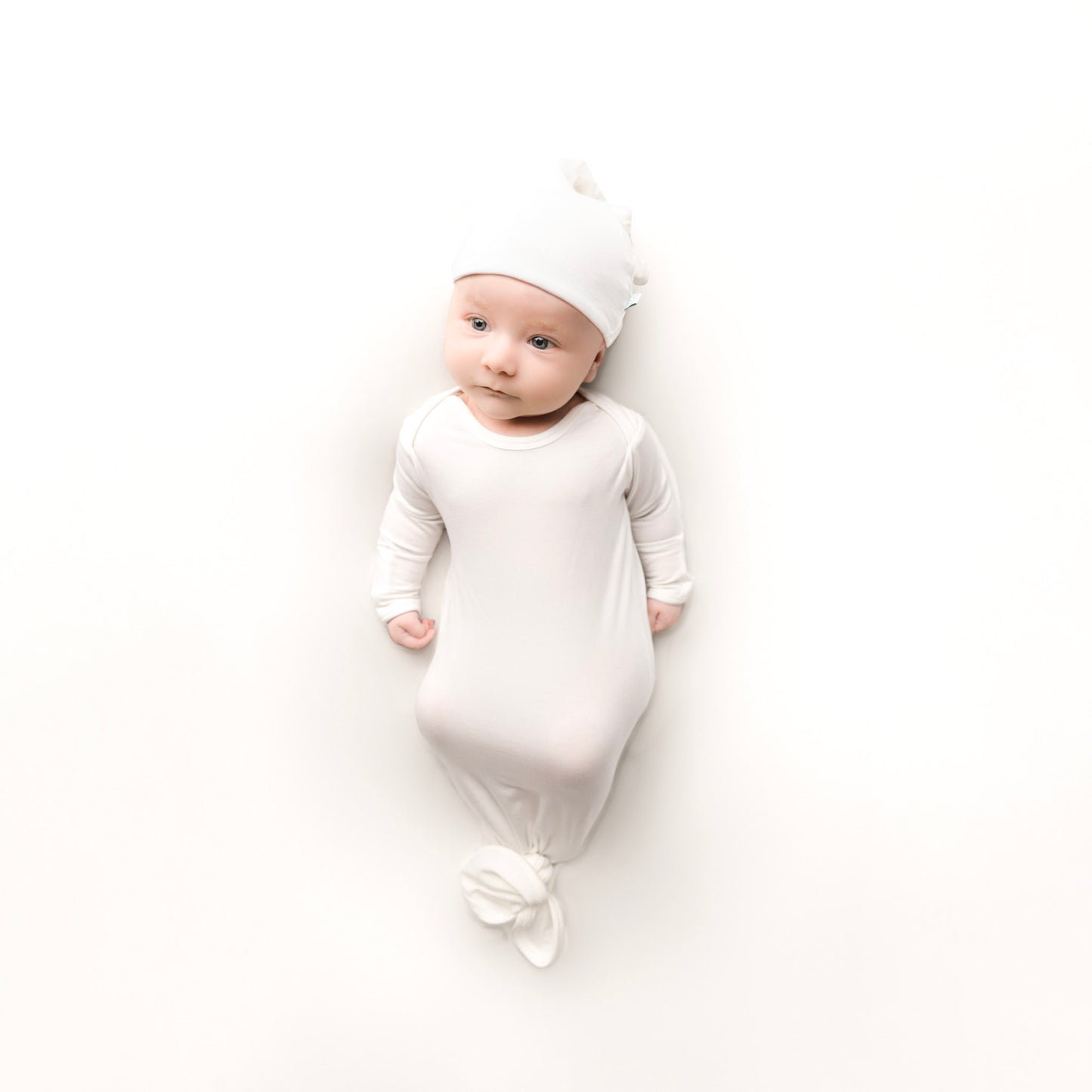 Baby wearing Cuddle sprouts white knotted gown set with hat made of tencel lyocell