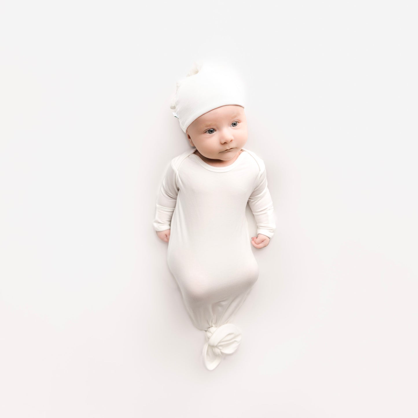 Baby wearing white knotted gown set with hat made of tencel lyocell