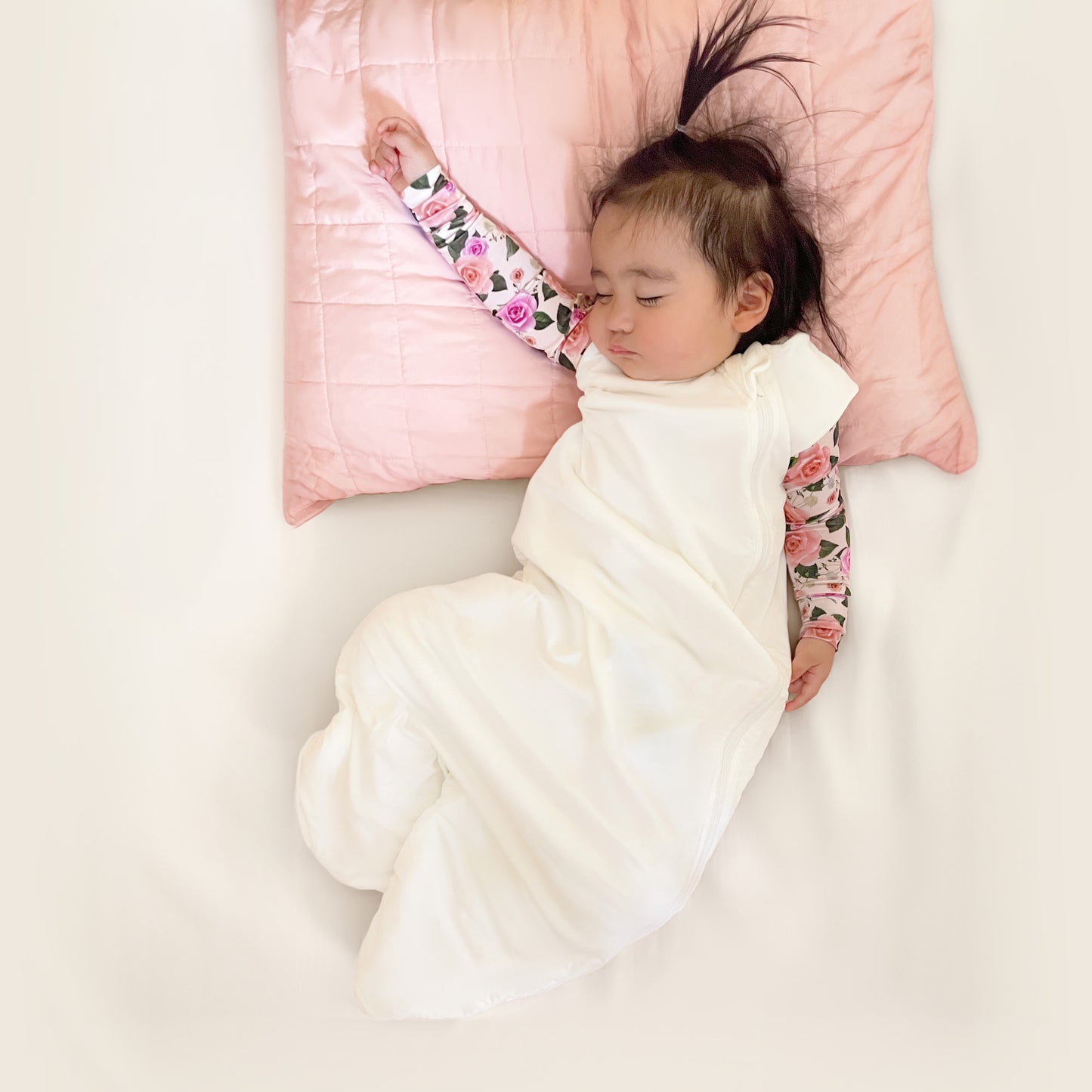 baby sleeping while wearing white sleep sack