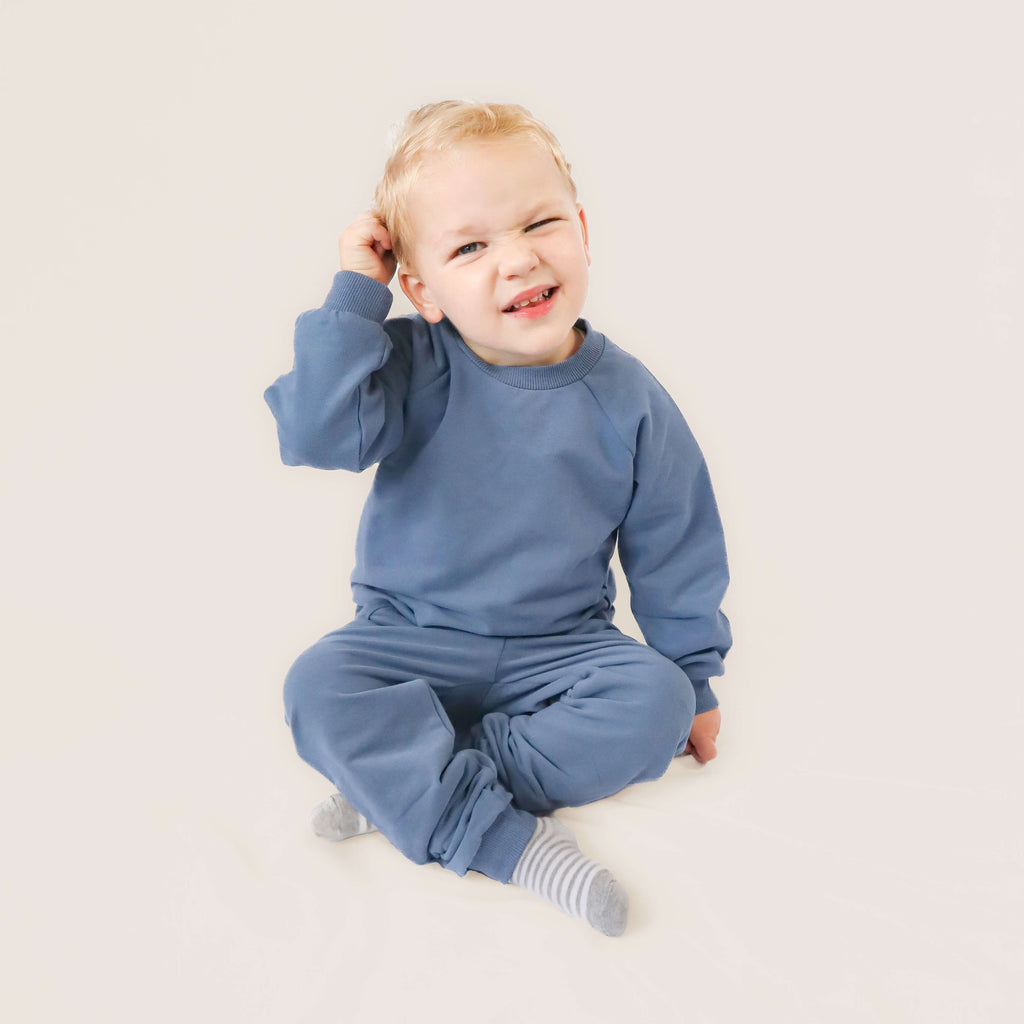 toddler sitting wearing blue jogger set