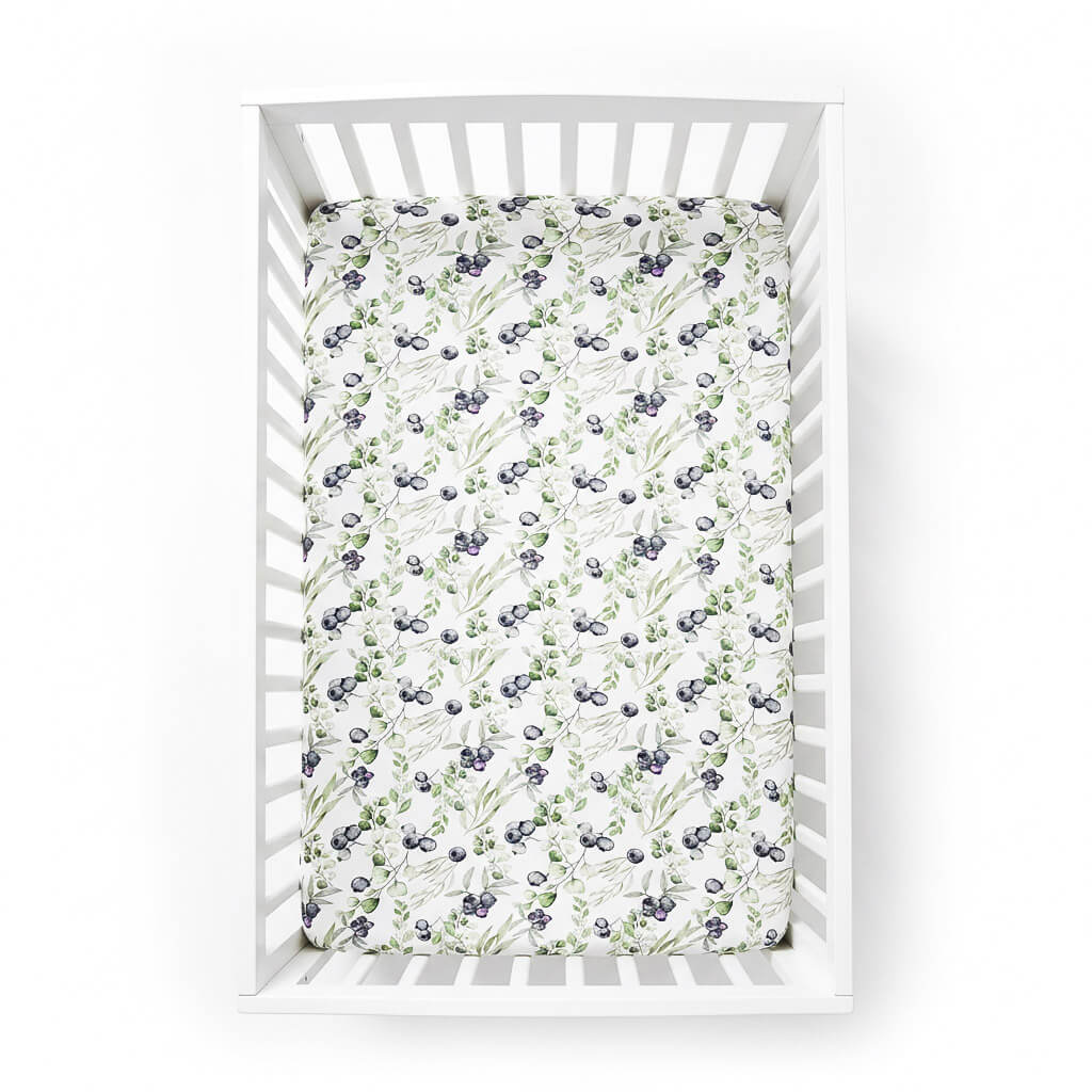 blueberry patterned crib sheet on a white crib