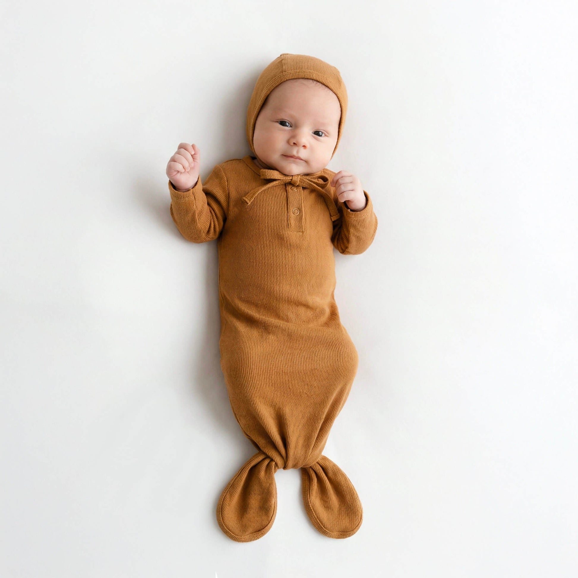 baby wearing brown gown