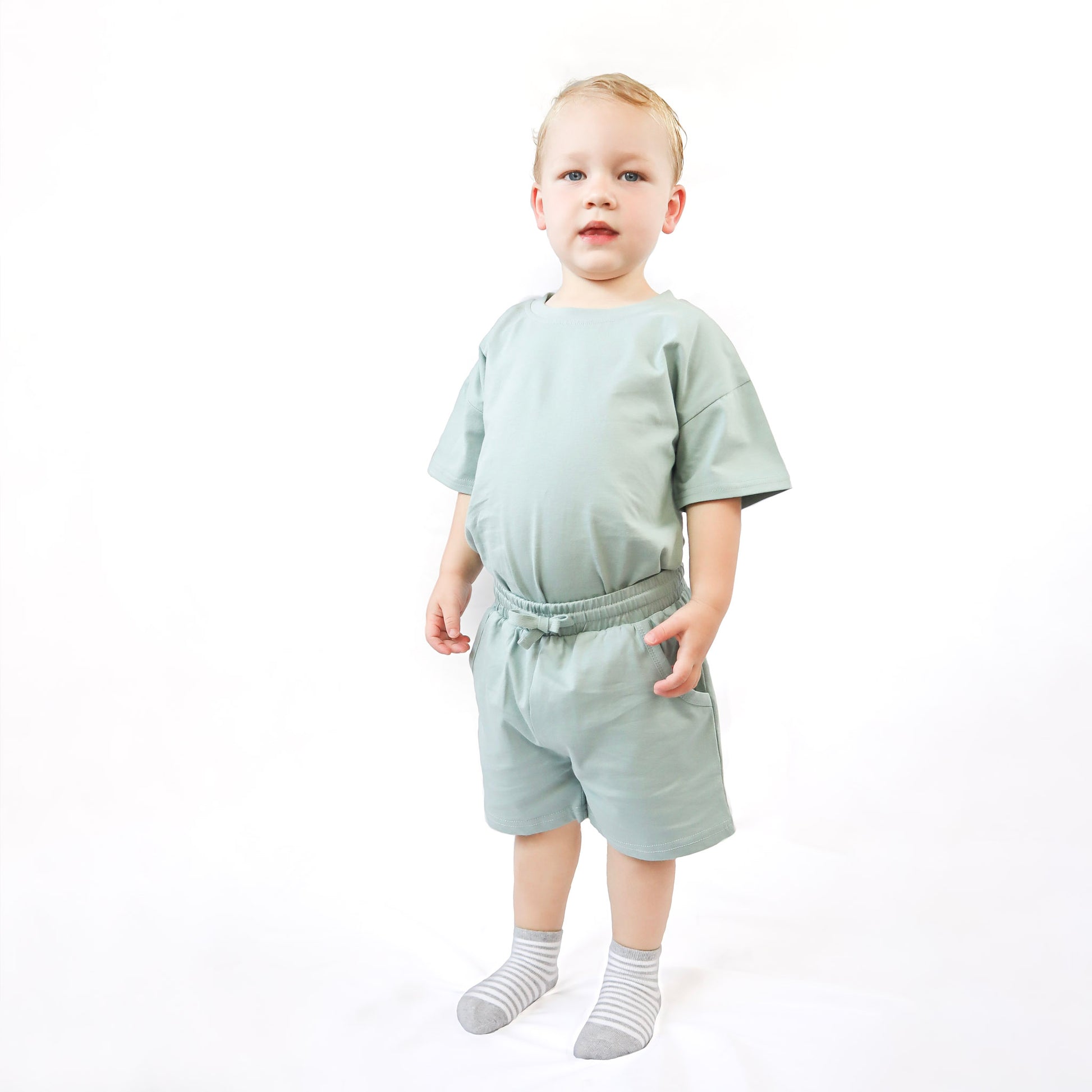 little boy wearing green sage set 