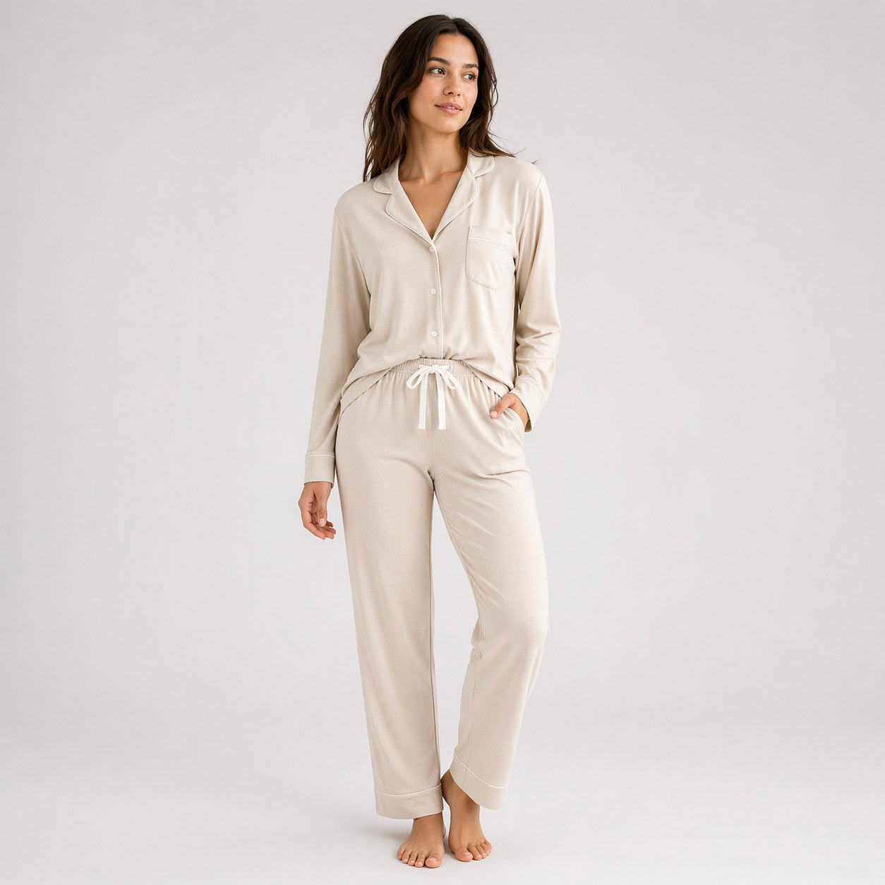 Woman wearing a beige pajama set on a white background