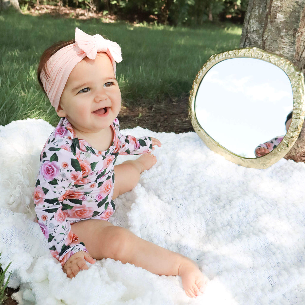 baby girl wearing floral bodysuit outdoors 