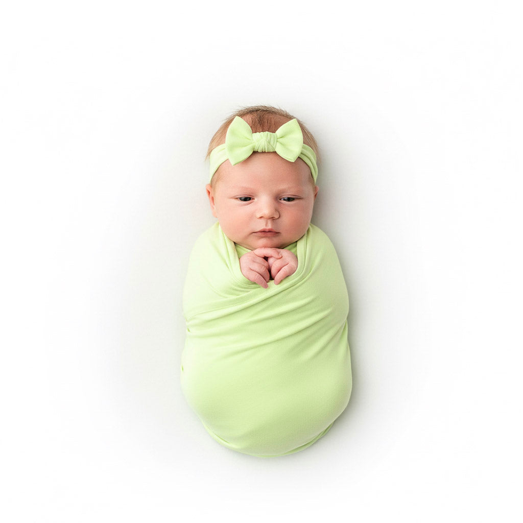 newborn baby wrapped in a green swaddle