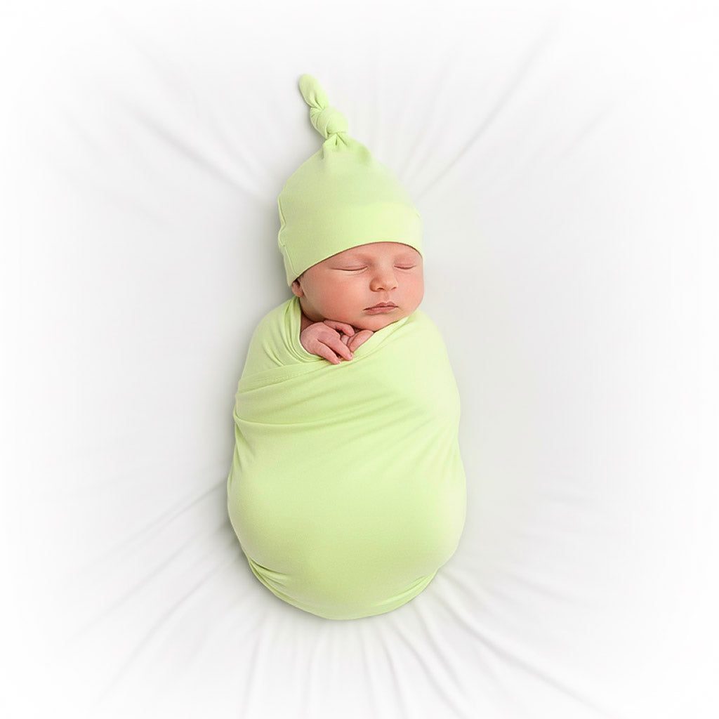 baby wrapped in green swaddle