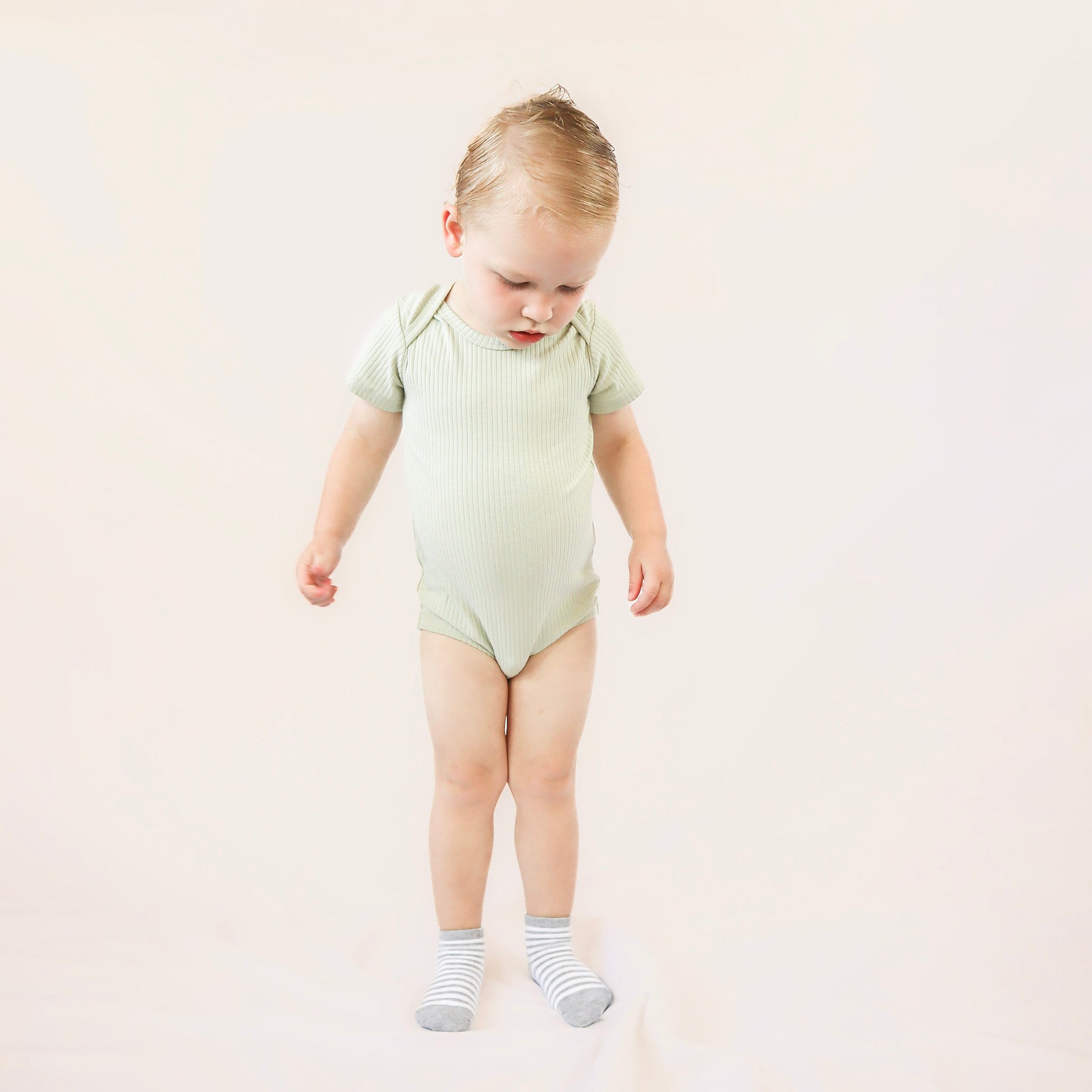 baby wearing light green organic cotton bodysuit