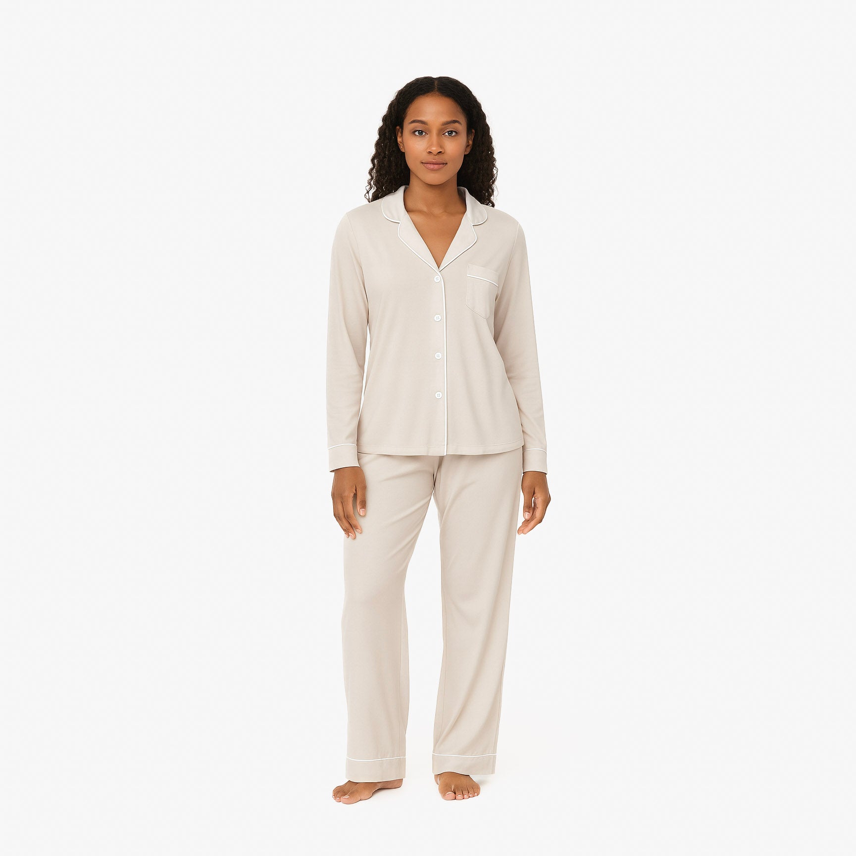 Woman wearing a beige pajama set on a white background