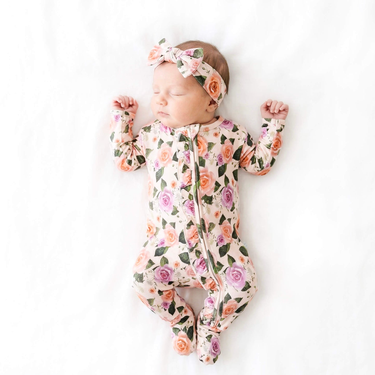 baby wearing floral footie pajamas