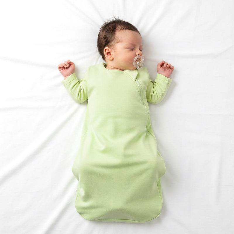 baby wearing green sleep sack