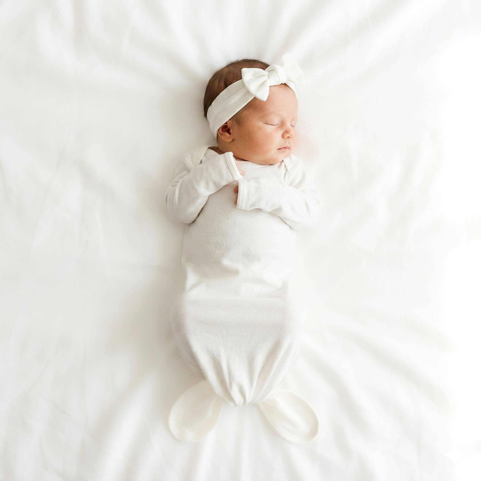 baby wearing white gown