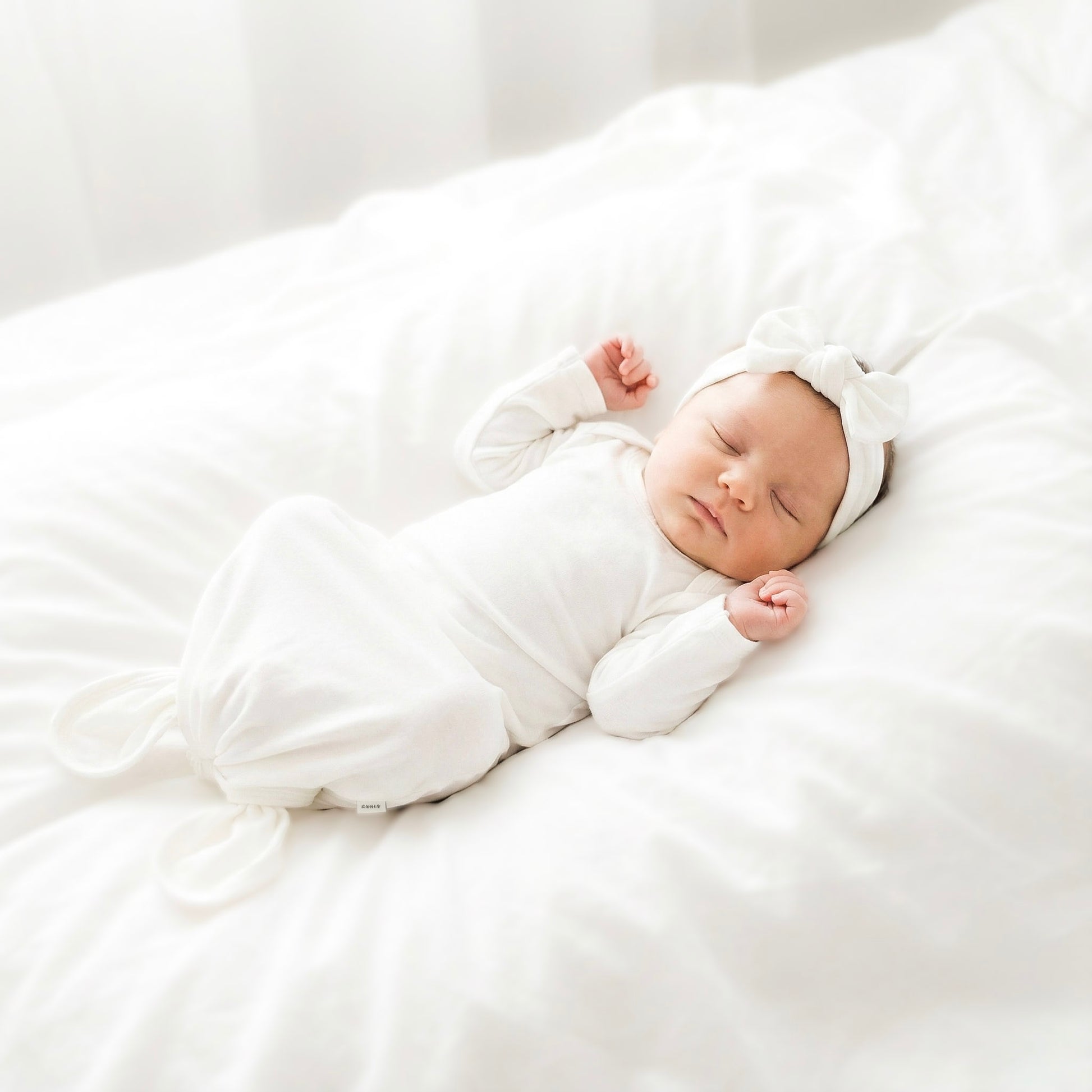 Newborn baby sleeping peacefully on a white blanket