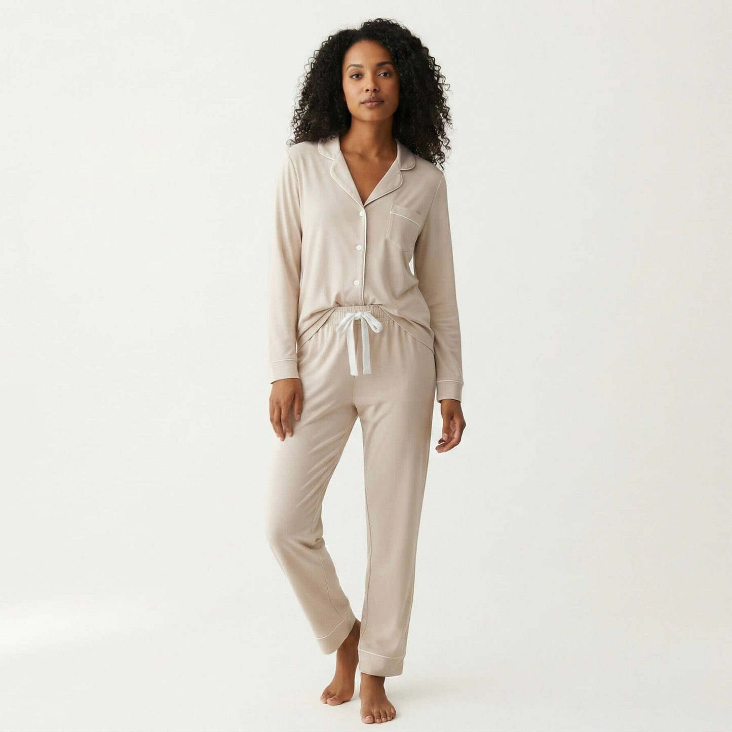 Woman wearing a beige pajama set on a white background